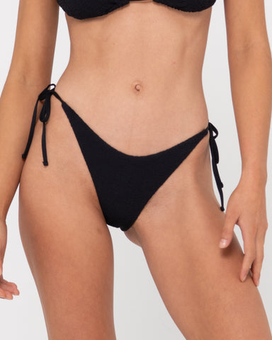 Woman wearing Sandalwood Midi Side Ties Bikini Pant in Black