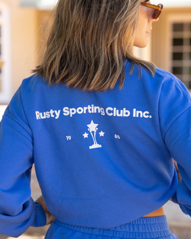 Woman wearing Rusty Sporting Club Crew Fleece in Dazzling Blue