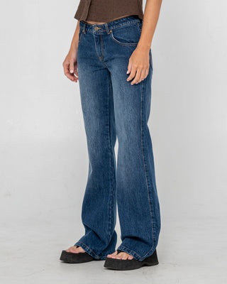 Woman wearing Shorty Freida Flare Low Rise Jeans in Blasted Deep Sea Blue