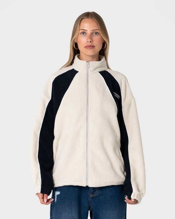 woman-wearing-two-tides-zip-through-sherpa-fleece-in-egret-navy-blue