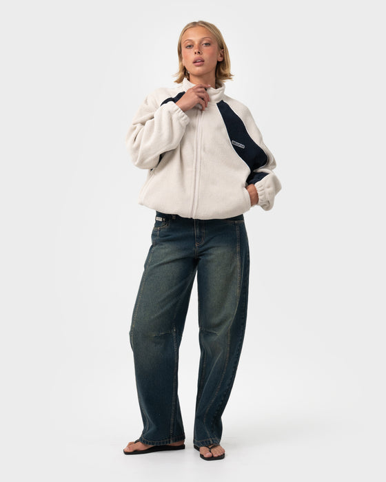 woman-wearing-two-tides-zip-through-sherpa-fleece-in-egret-navy-blue