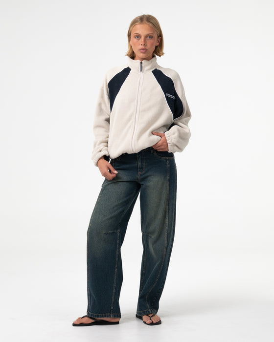 woman-wearing-two-tides-zip-through-sherpa-fleece-in-egret-navy-blue