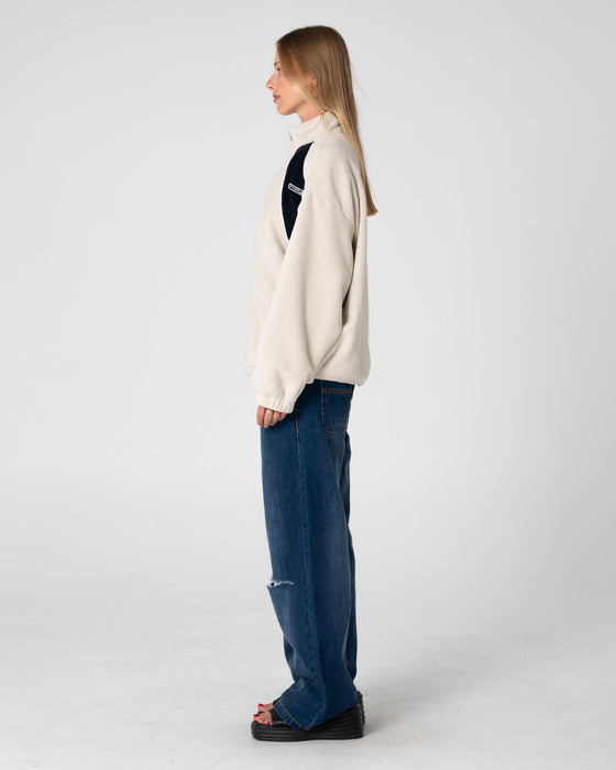 woman-wearing-two-tides-zip-through-sherpa-fleece-in-egret-navy-blue