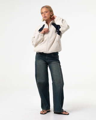 Woman wearing Two Tides Zip Through Sherpa Fleece in Egret / Navy Blue