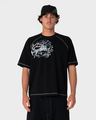 Man wearing Riddle Me This Short Sleeve Tee in Black