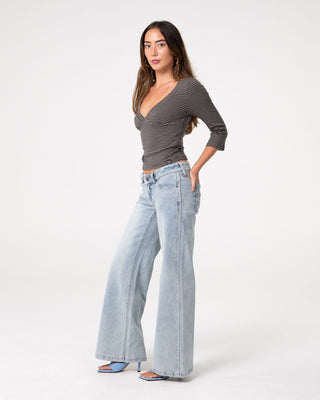 Woman wearing Lori Super Low Rise Wide Leg Denim Jean in Worn Out