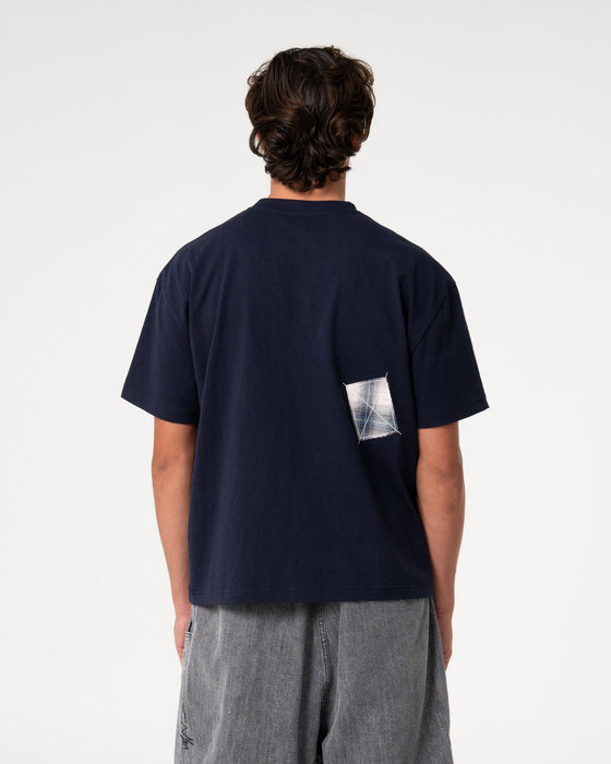 man-wearing-uncut-gems-short-sleeve-tee-in-navy-blue