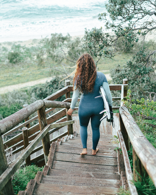 Women wearing A Series Ecoprene 3/2 Chest Zip Long Sleeve Steamer Wetsuit in Crystal Blue