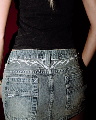 Woman wearing Morty Low Rise Denim Micro Mini Skirt in Dirty Dawg
