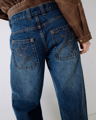 Woman wearing Rip In Wendy Wide Low Rise Denim Jean in Blasted Deep Sea Blue