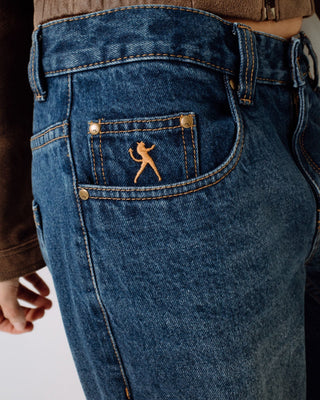 Woman wearing Rip In Wendy Wide Low Rise Denim Jean in Blasted Deep Sea Blue