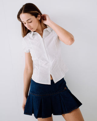 Woman wearing Poppy Pleated Denim Mini Skirt in Deep Sea Blue