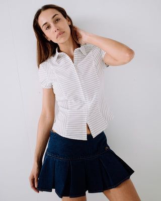 Woman wearing Poppy Pleated Denim Mini Skirt in Deep Sea Blue