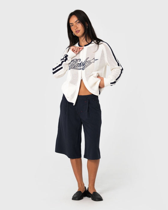 woman-wearing-eugene-zip-through-knit-in-egret-navy-blue