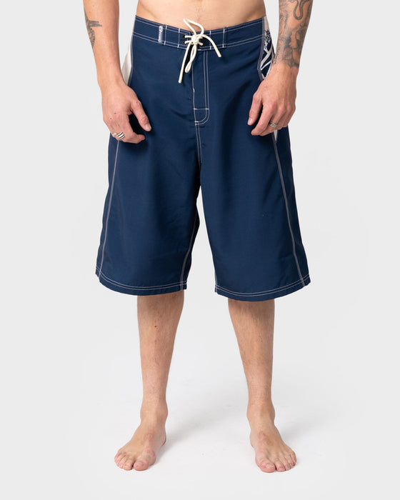 man-wearing-oxecutioner-fixed-waist-boardshort-in-navy-blue