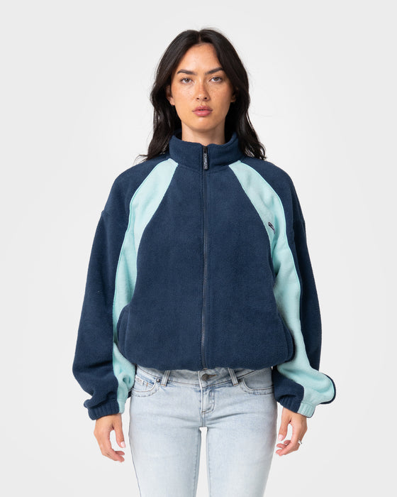 woman-wearing-two-tides-zip-through-sherpa-fleece-in-navy-light-blue
