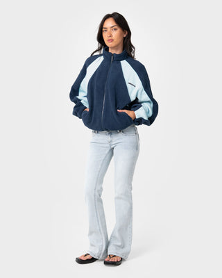 Woman wearing Two Tides Zip Through Sherpa Fleece in Navy /Light Blue