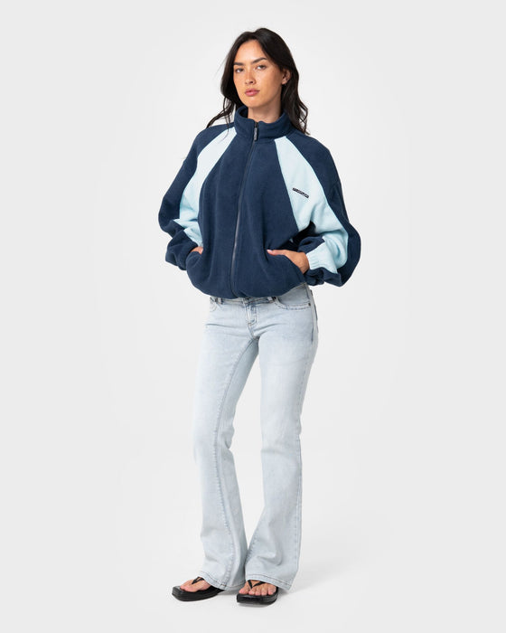 woman-wearing-two-tides-zip-through-sherpa-fleece-in-navy-light-blue
