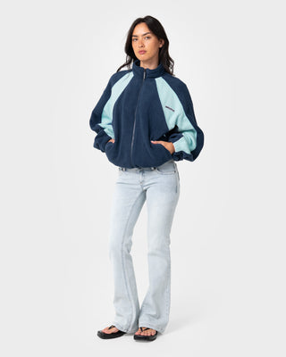 Woman wearing Two Tides Zip Through Sherpa Fleece in Navy / Light Blue