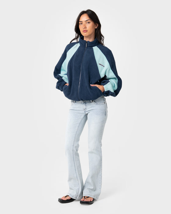 woman-wearing-two-tides-zip-through-sherpa-fleece-in-navy-light-blue
