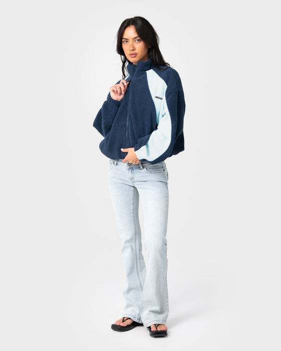 woman-wearing-two-tides-zip-through-sherpa-fleece-in-navy-light-blue