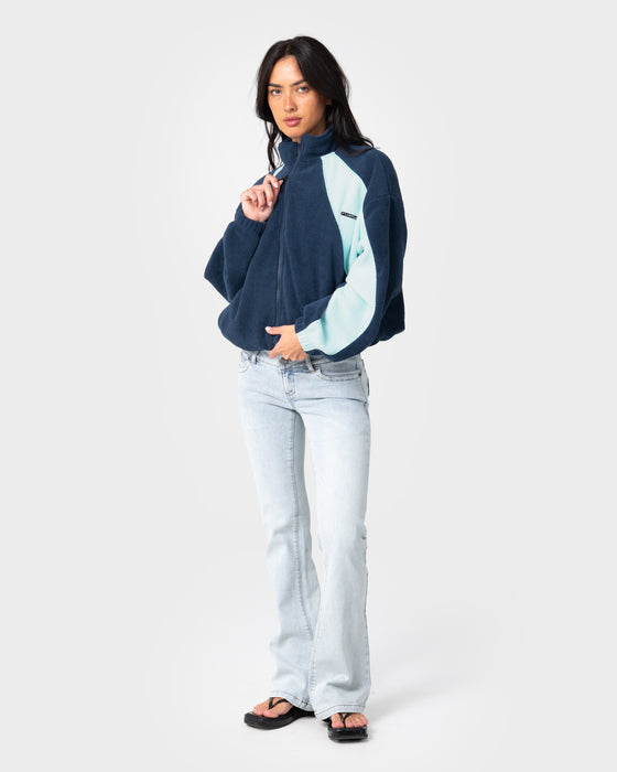 woman-wearing-two-tides-zip-through-sherpa-fleece-in-navy-light-blue