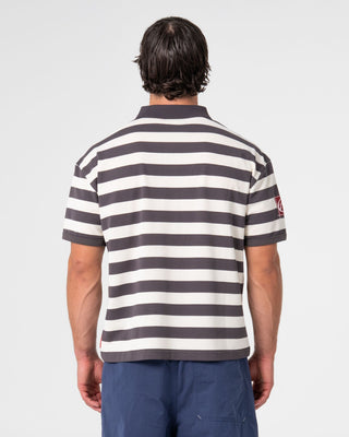 Man wearing Thrasha Short Sleeve Polo in Carbon