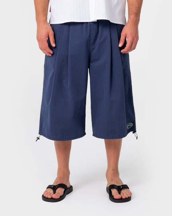 man-wearing-mamba-3-4-baggy-short-in-dark-blue