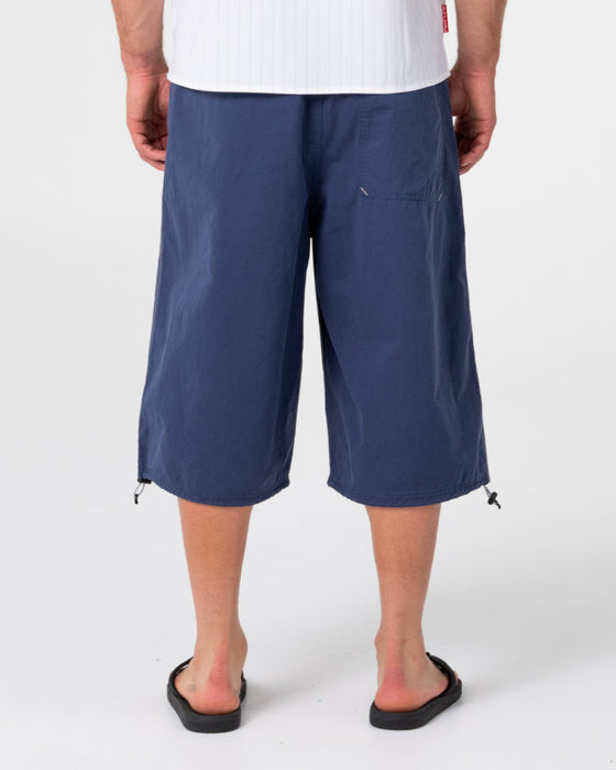 man-wearing-mamba-3-4-baggy-short-in-dark-blue