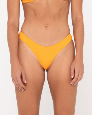 Woman wearing Sandalwood Brazilian Bikini Pant in Bright Tangerine