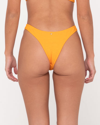 Woman wearing Sandalwood Midi Bikini Pant in Bright Tangerine