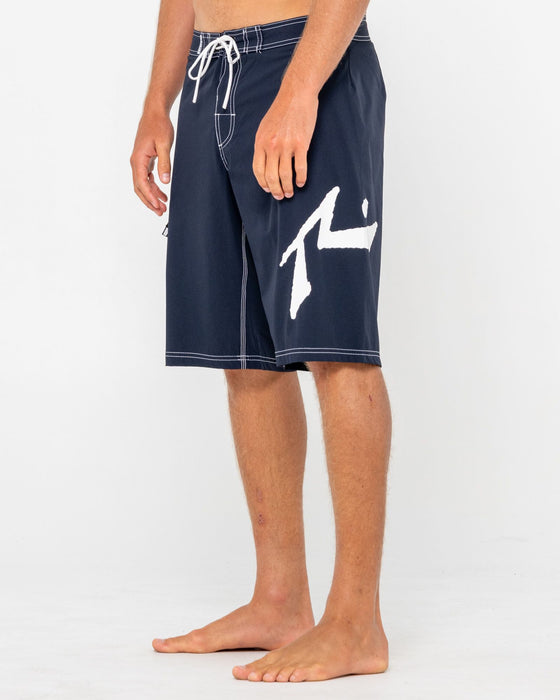 man-wearing-fixed-competition-revolution-boardshort-in-navy-blue