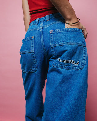 Woman wearing Flip Mommy Low Rise Wide Leg Denim Jean in Middy Blue / Orange