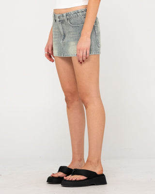 Woman wearing Norty Low Rise Denim Micro Mini Skirt in Dirty Dawg