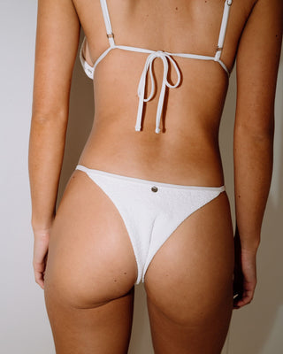 Woman wearing Sandalwood Ring Cheeky Bikini Bottom in Bright White