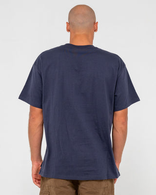 Man wearing Vital Rusty Short Sleeve Tee in Navy Blue 1