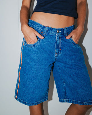 Woman wearing Flip Mommy Low Rise Wide Leg Denim Jort in Middy Blue / Orange