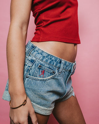 Woman wearing Norty Pheonix Low Rise Denim Mini Short in Dirty Dawg