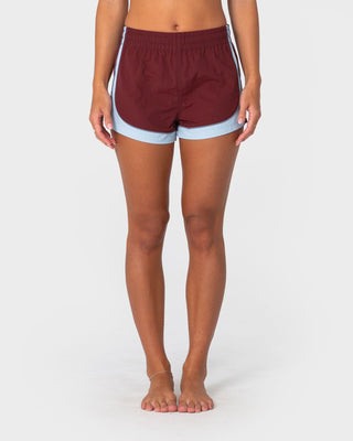 Woman wearing Elastic Panel Crank Boardshort in Cranberry / Retro Blue