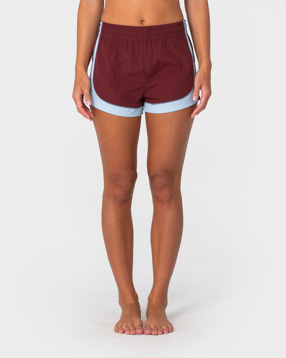 woman-wearing-elastic-panel-crank-boardshort-in-cranberry-retro-blue