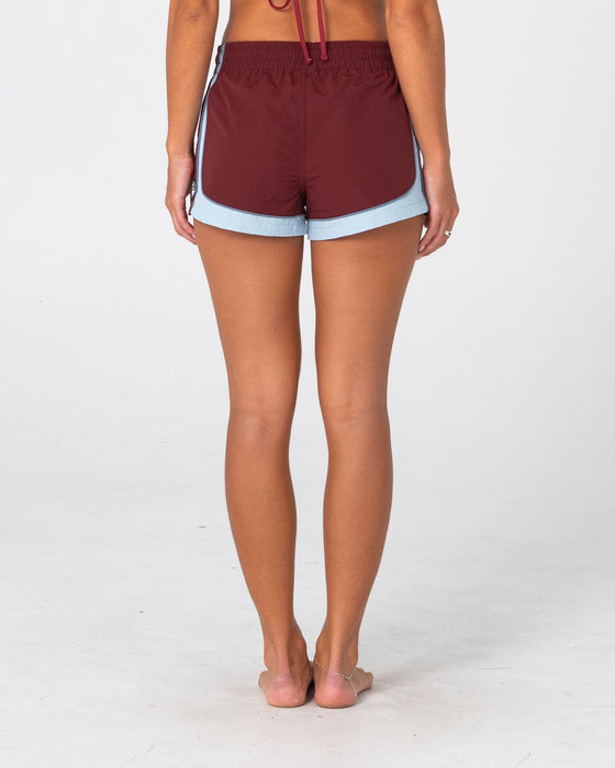 woman-wearing-elastic-panel-crank-boardshort-in-cranberry-retro-blue
