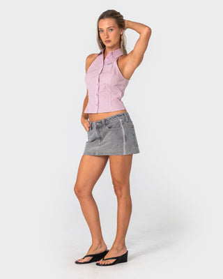 Woman wearing Flip Mommy Low Rise Mini Denim Skirt 2.0 in London Summer / Baby Pink