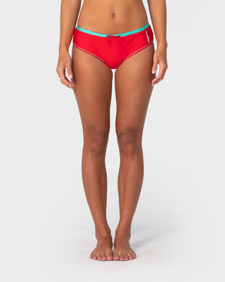 Woman wearing Voltron Booty Bikini Bottom in Tomato / Aqua