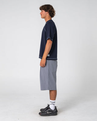 Man wearing Riddle Me This Short Sleeve Tee in Navy Blue