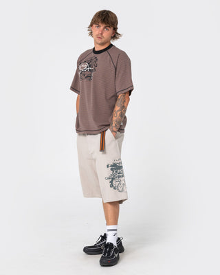Man wearing Riddle Me This Short Sleeve Tee in Pinecone