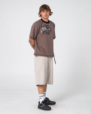 Man wearing Riddle Me This Short Sleeve Tee in Pinecone