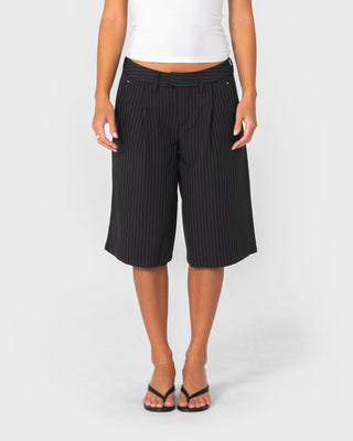 Woman wearing Big Bad Finance Mommy Low Rise Short in Black Pinstripe