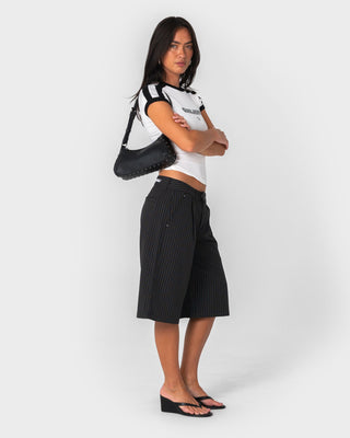 Woman wearing Big Bad Finance Mommy Low Rise Short in Black Pinstripe
