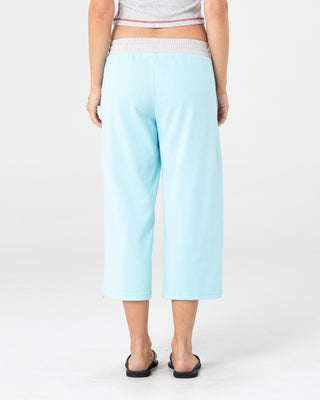 Woman wearing Maneater Low Rise Capri Track Pant in Powder Aqua