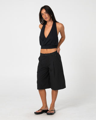 Woman wearing Big Bad Finance Mommy Low Rise Short in Black Pinstripe